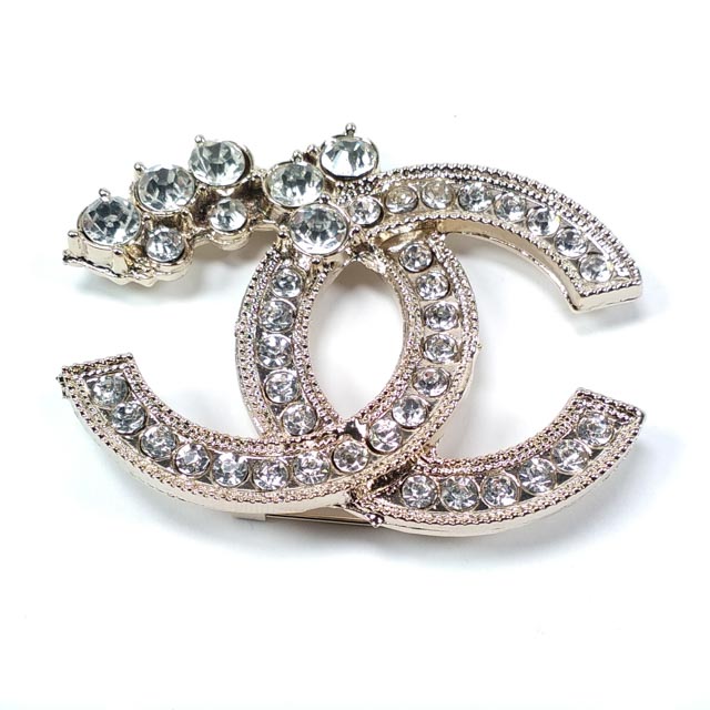 Product view of stone-detailed classic emblem brooch
