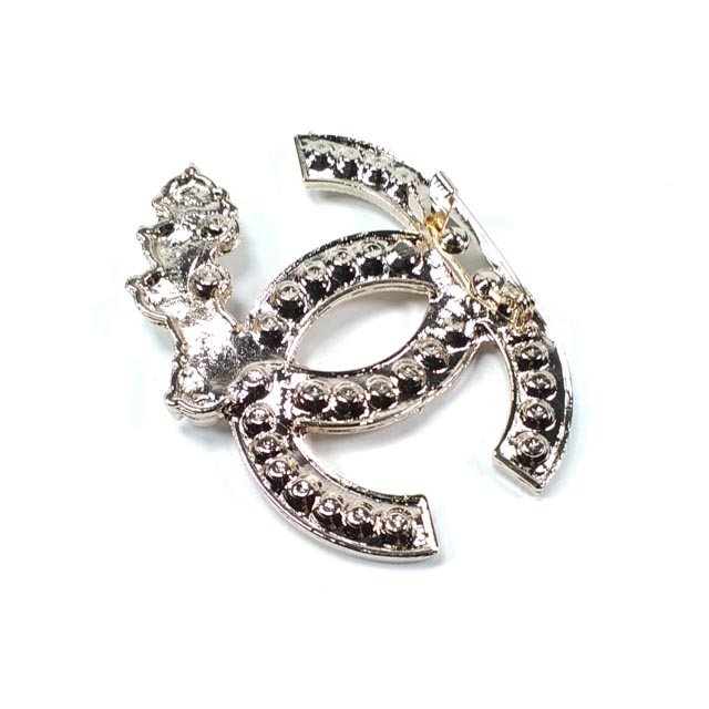 Product view of stone-detailed classic emblem brooch